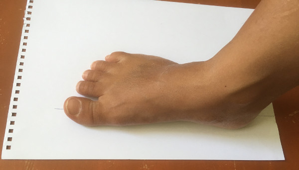 place foot for shoe size measurement on paper at home